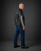 Side view of the black quilted leather motorcycle jacket featuring quilted shoulder panels, zippered pockets, and striped sleeve accents, worn by a man.