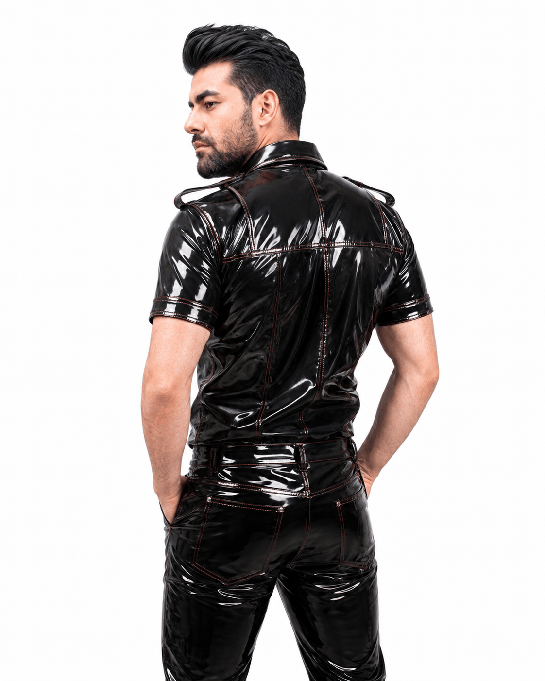 Side profile of a male model wearing a black PVC fetish shirt with shiny finish, detailed collar, and shoulder epaulets, against a white background.