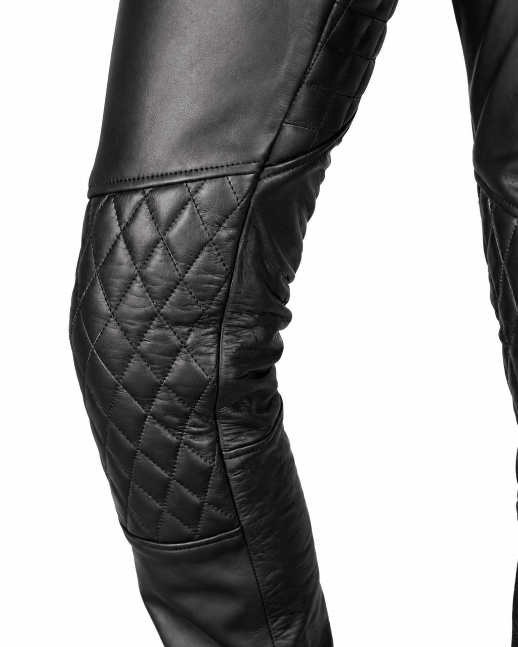 Black leather pants with quilted detailing on thighs and knees, showing a high waist with a belt and zipper fly, styled for biker gear.